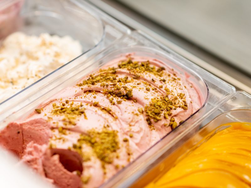 Close-up of ice cream with different flavors in the refrigerator on a shop window